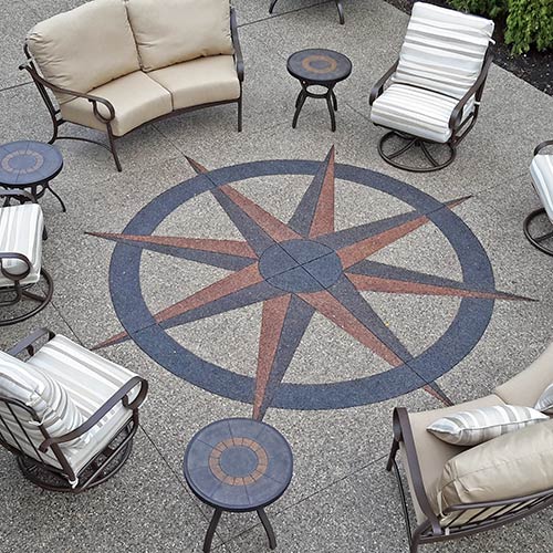 Hand-cut compass stamp in exposed aggregate patio