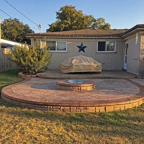 Two-level stamped concrete patio with fire pit installed