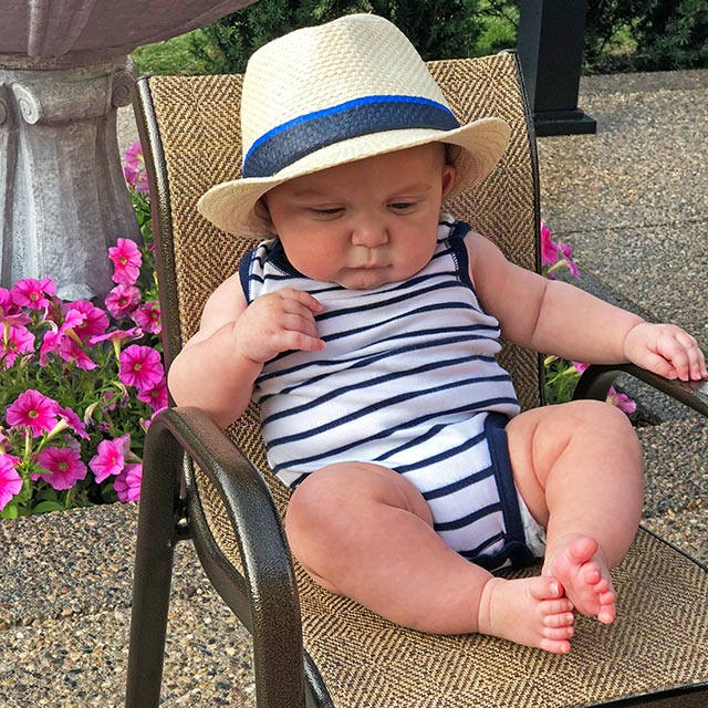 Baby lounges on exposed aggregate patio in New Haven, Michigan